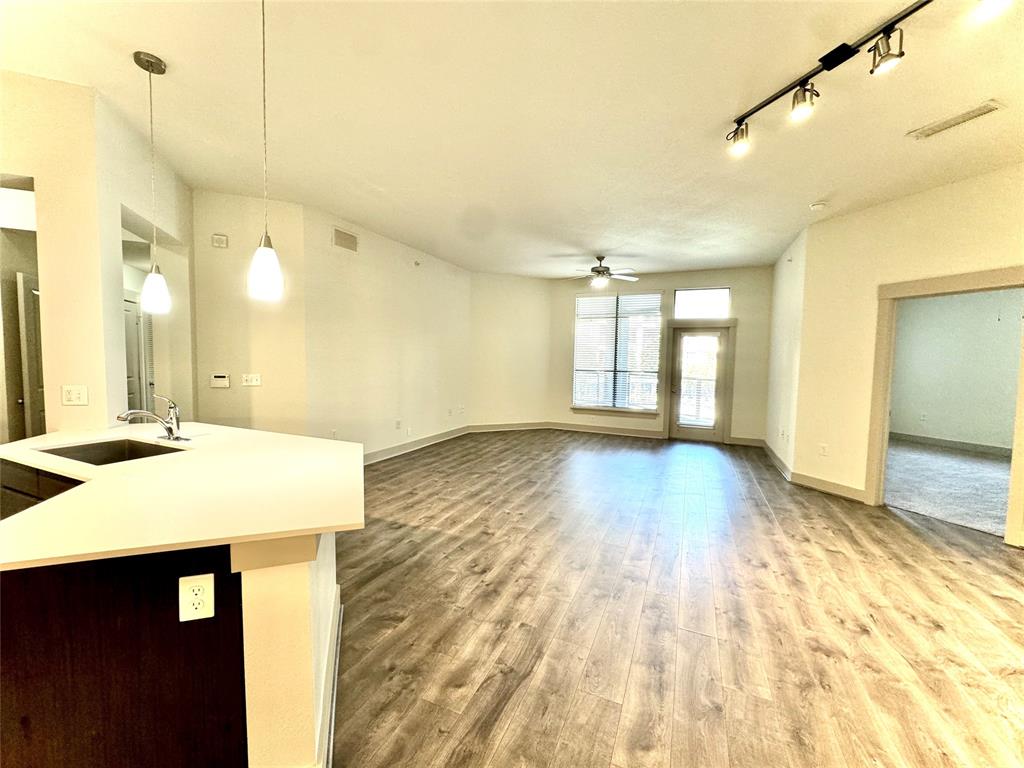 a view of a room with wooden floor and a window