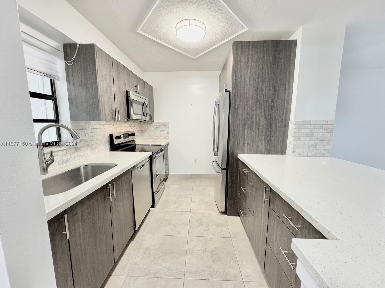 a kitchen with stainless steel appliances a sink stove and cabinets