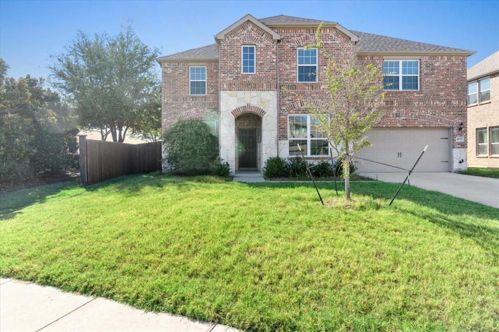 a front view of a house with a garden and yard