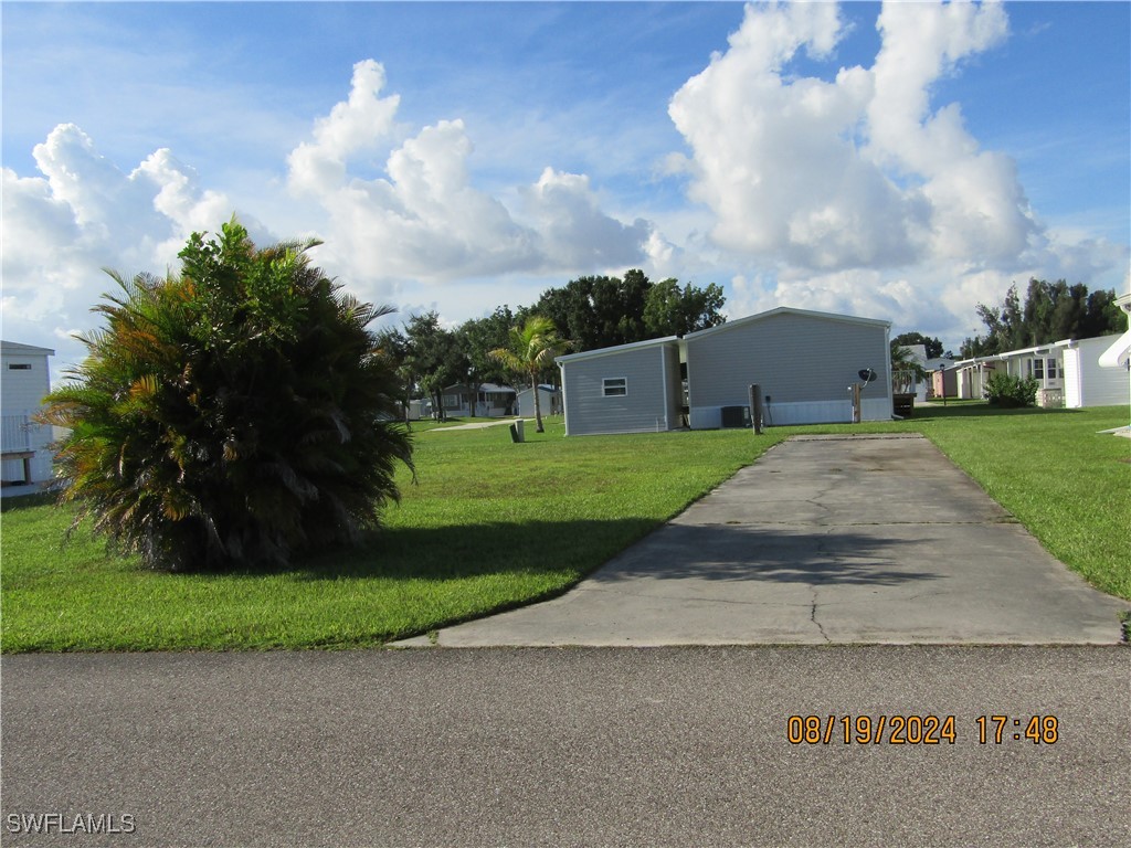 a view of a house with a big yard and a large trees