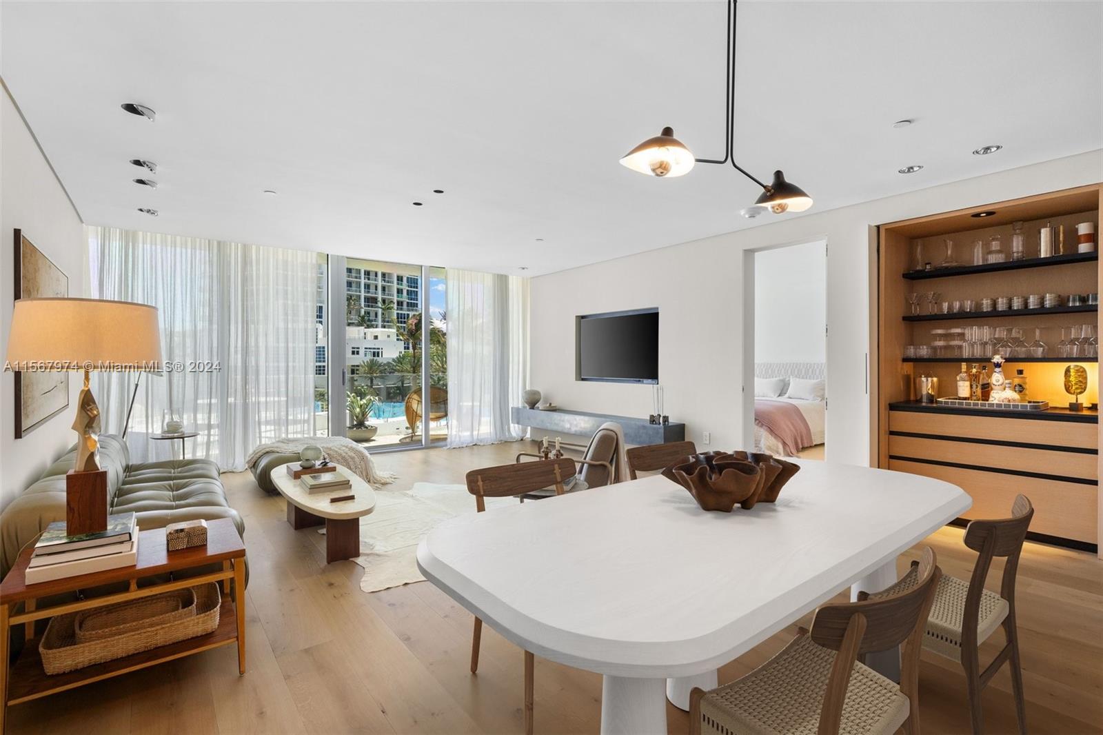 a living room with furniture a flat screen tv and a large window