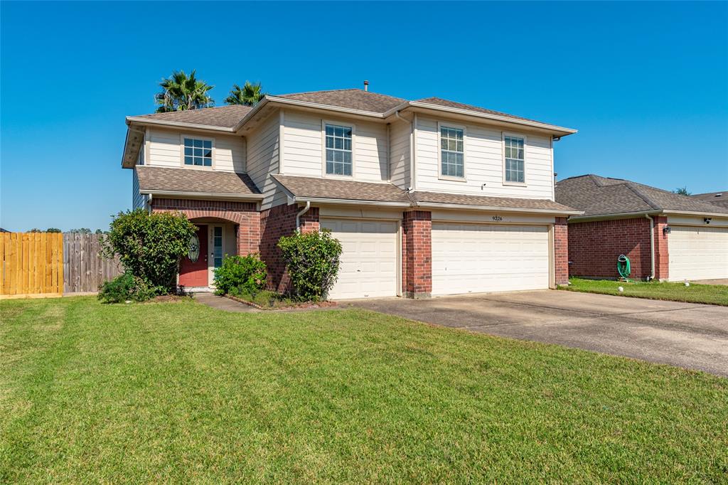 a front view of a house with a yard and garage