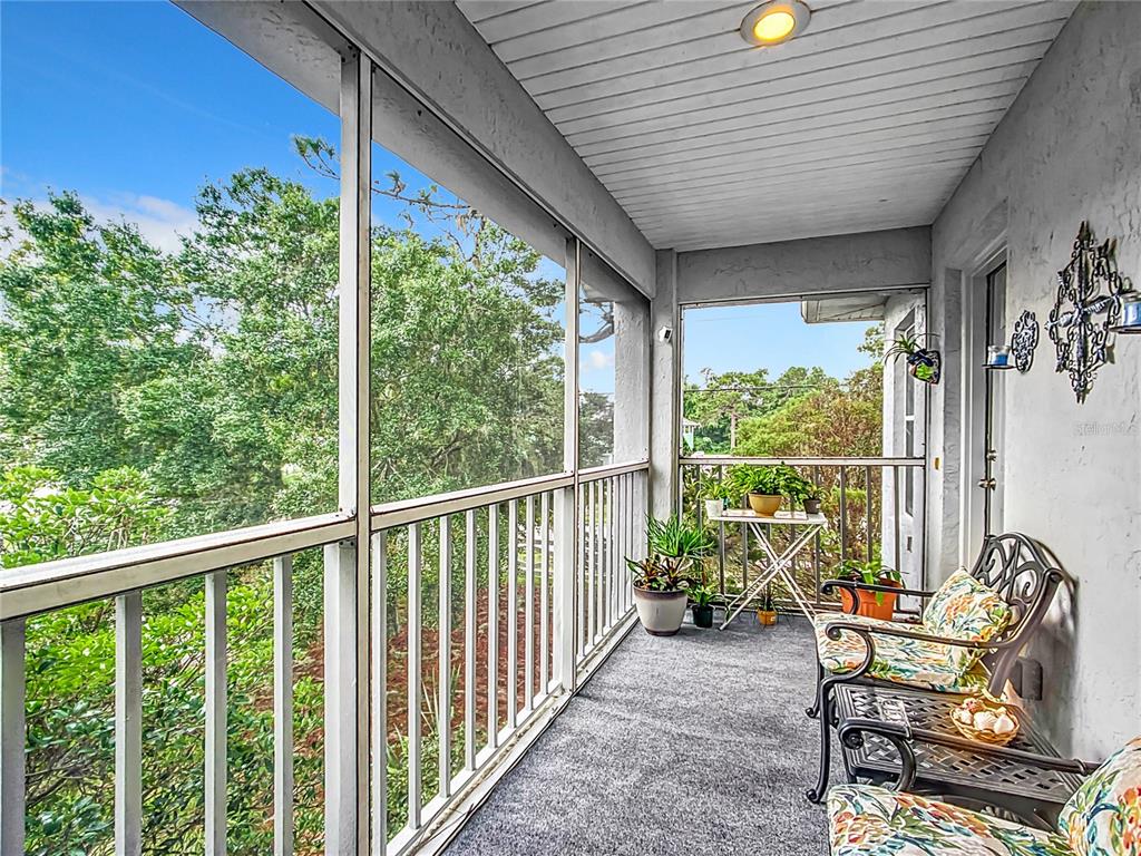 a balcony with furniture and wooden floor