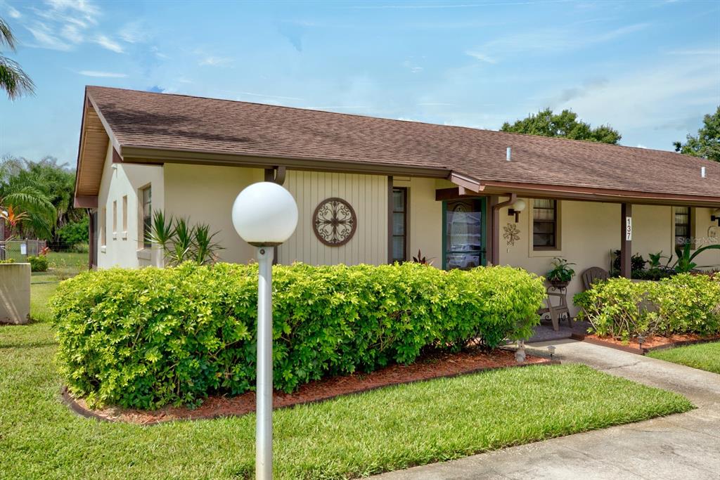 a front view of a house with a yard and potted plants