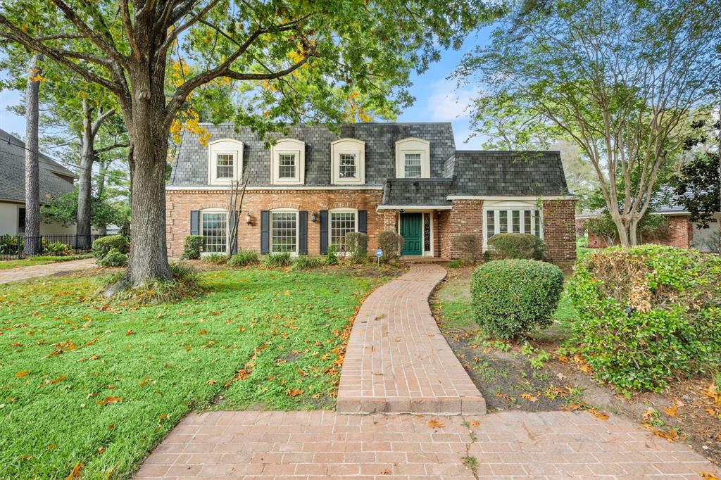 front view of a brick house with a yard