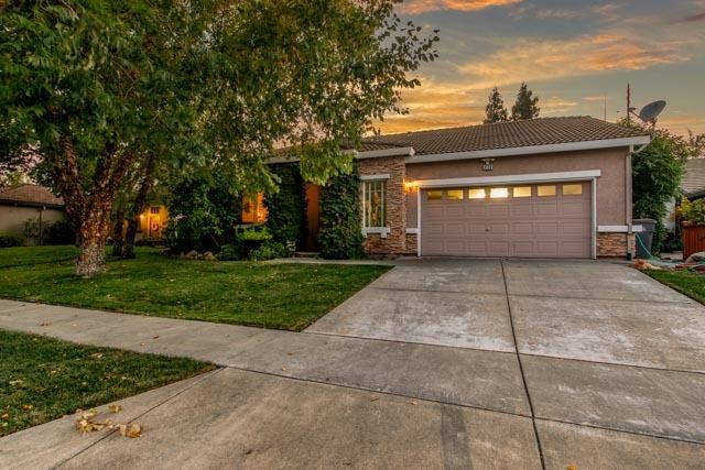 a front view of a house with a yard and a garden