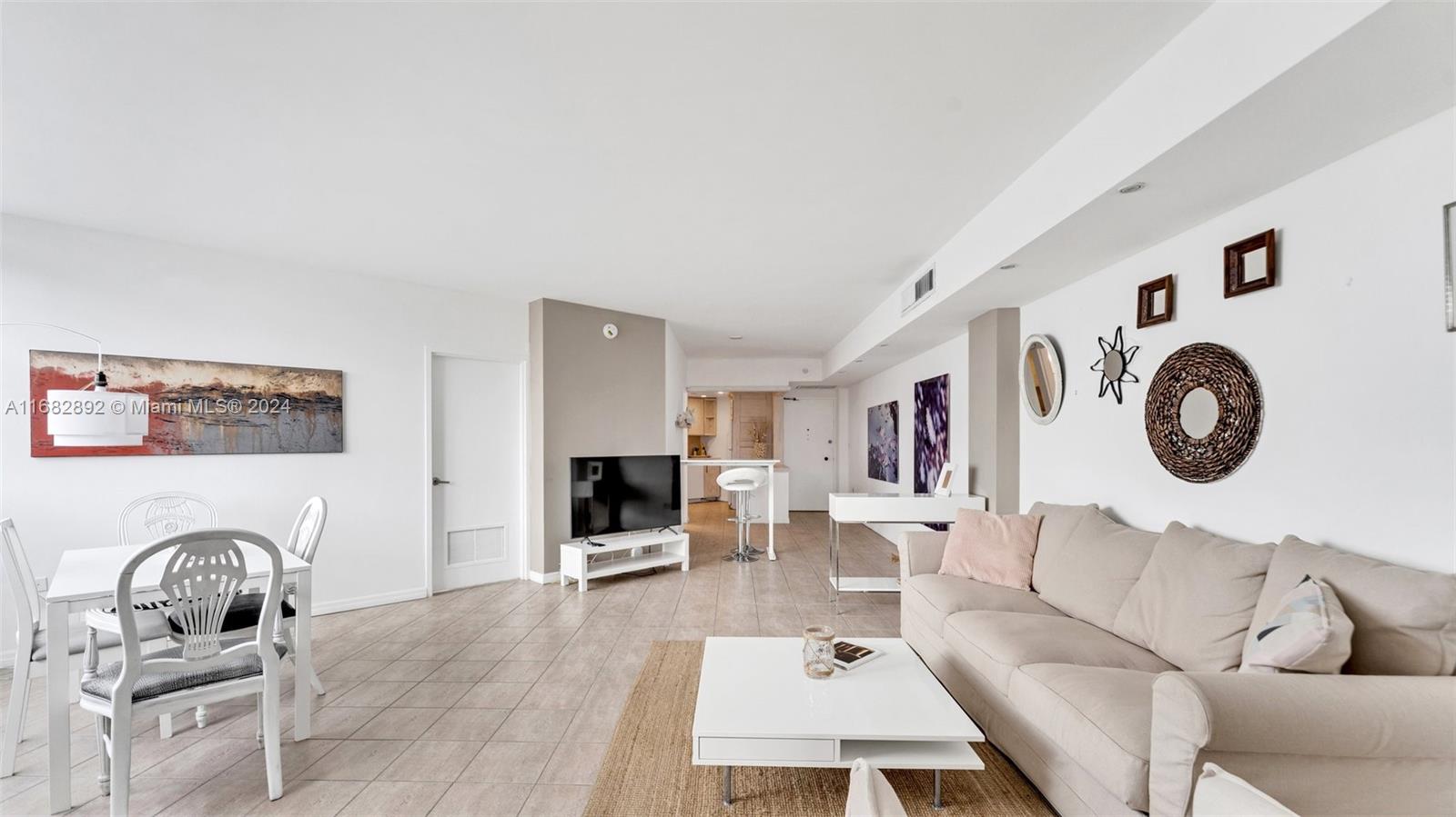 a living room with furniture and kitchen