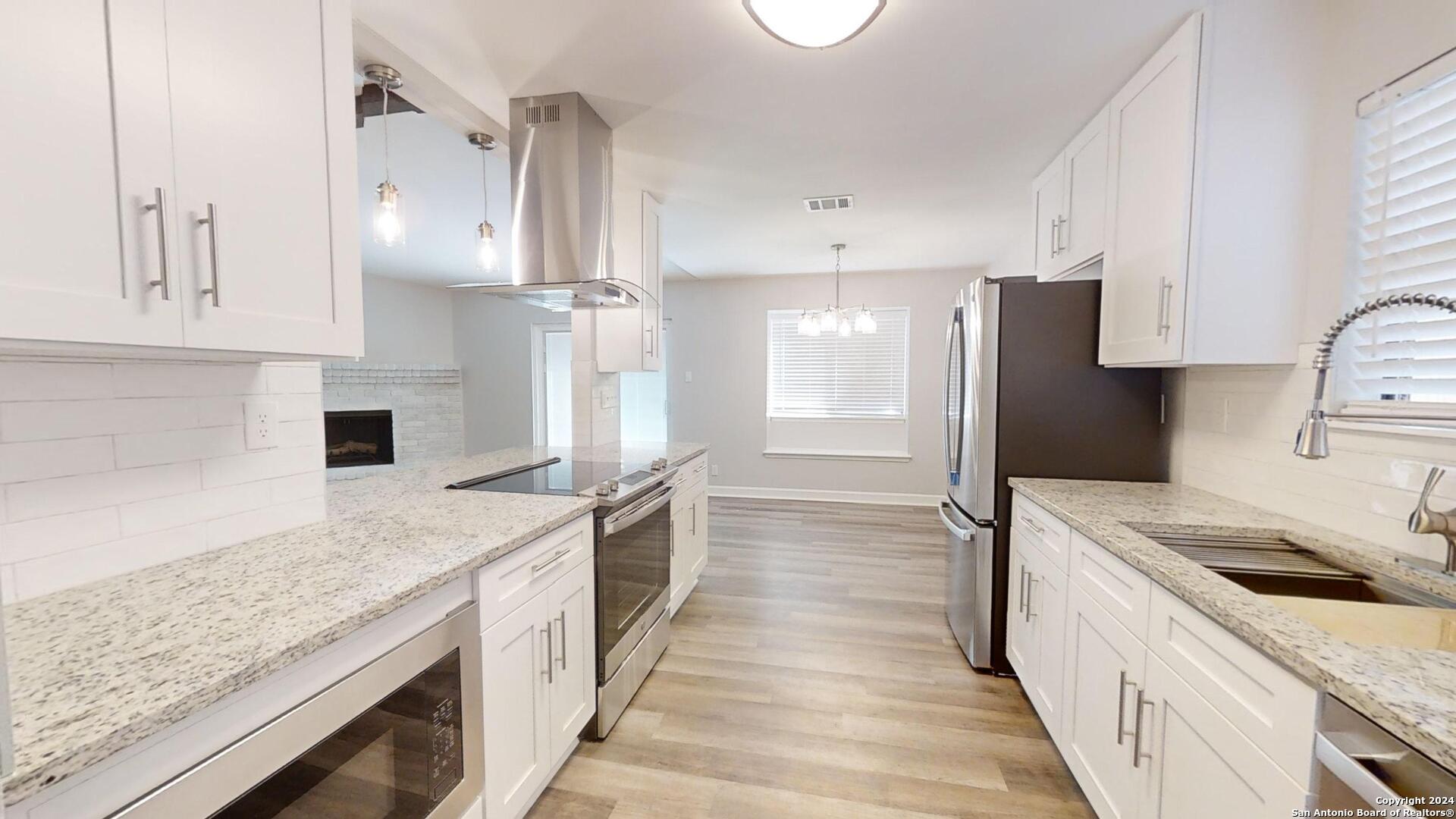 a kitchen with stainless steel appliances granite countertop a sink stove and refrigerator