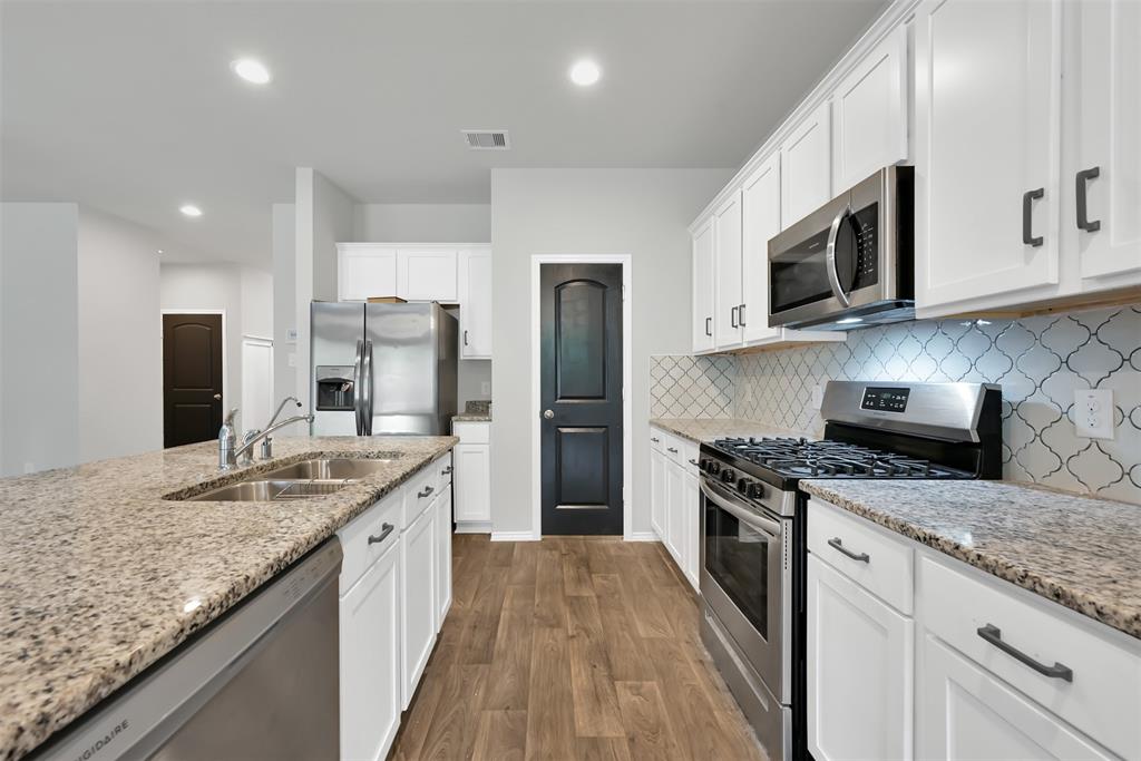 a kitchen with stainless steel appliances granite countertop a sink stove and refrigerator