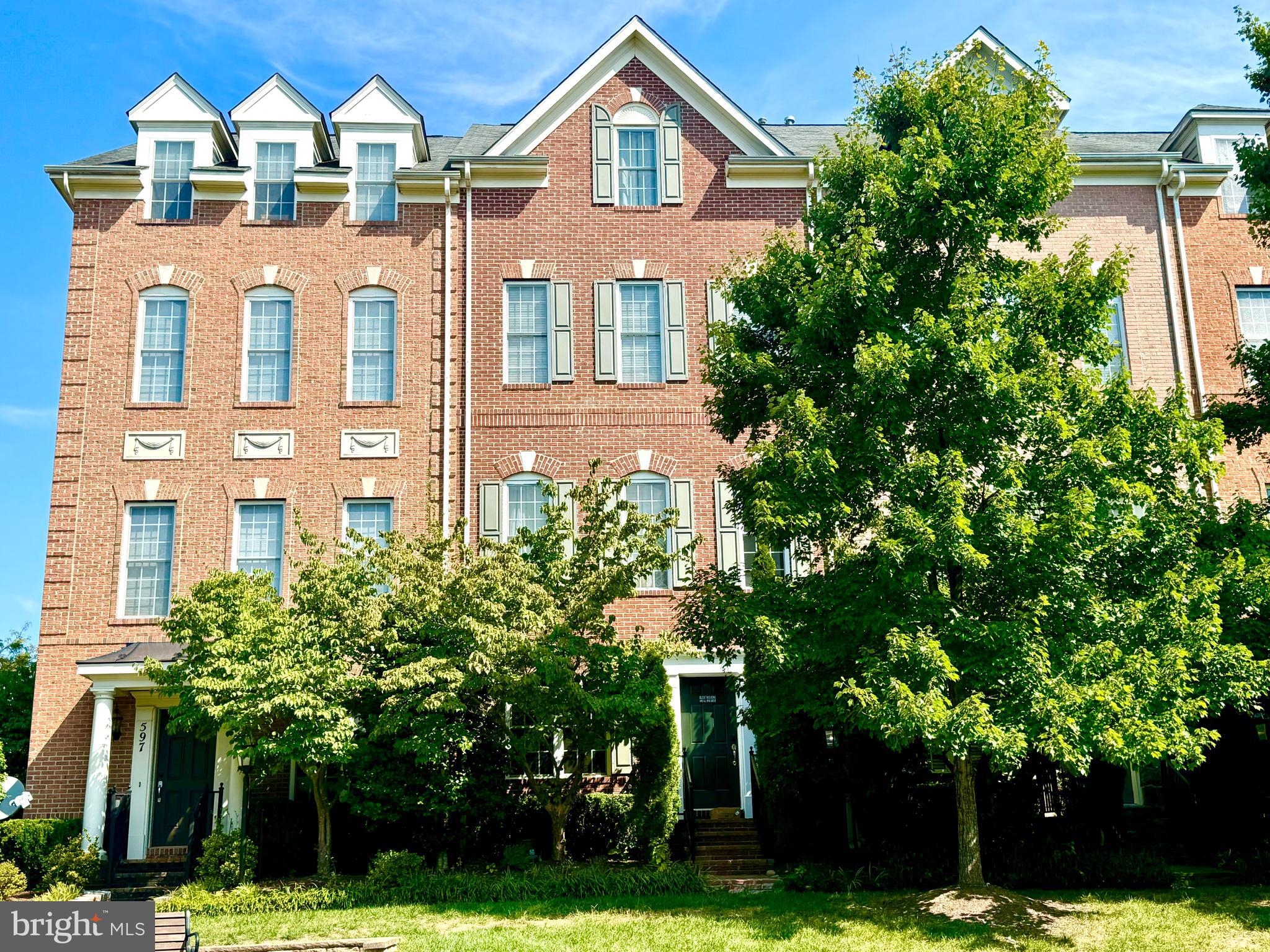 a front view of a residential houses with yard and green space