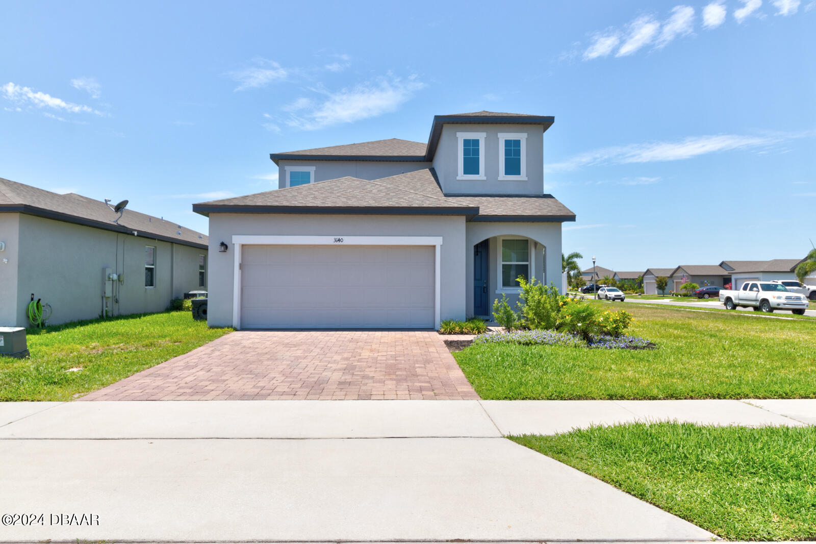 a front view of a house with a yard and garage