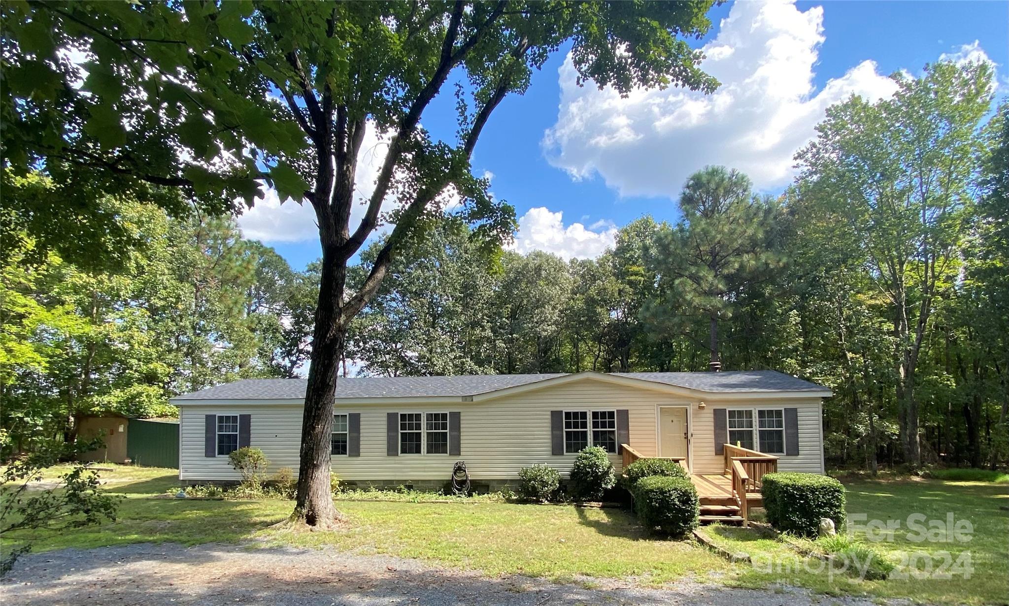 a front view of a house with yard and green space