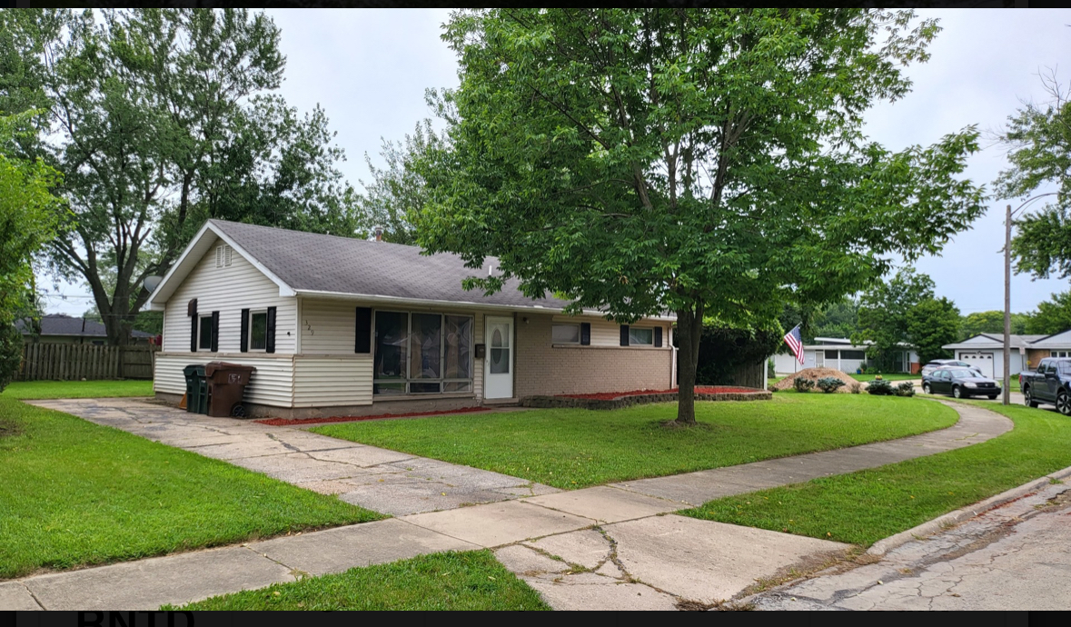 a front view of a house with a yard and sitting area