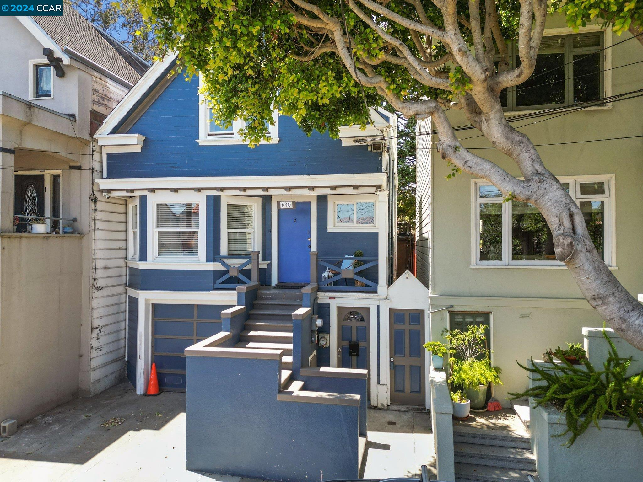 a view of a building with potted plants and a tree