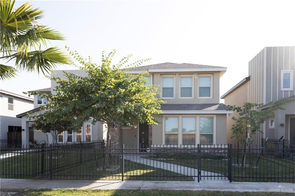 a front view of a house with a tree