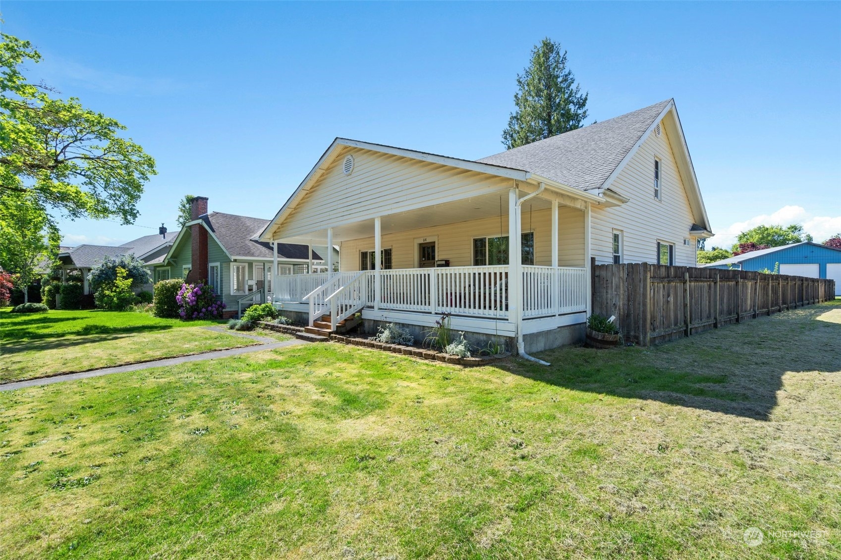 a view of a house with a yard and wooden fence