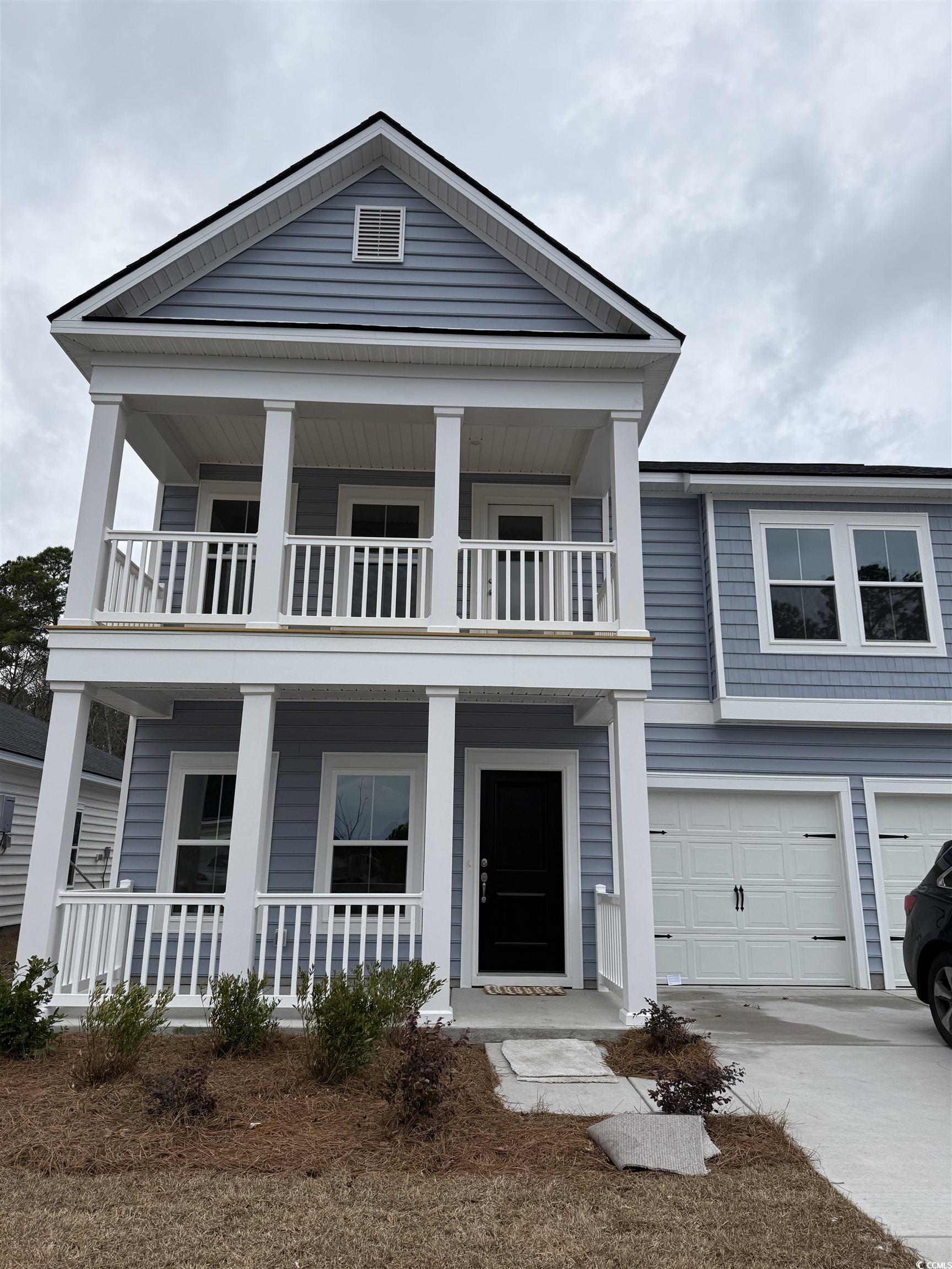 View of front of home with a garage and a balcony