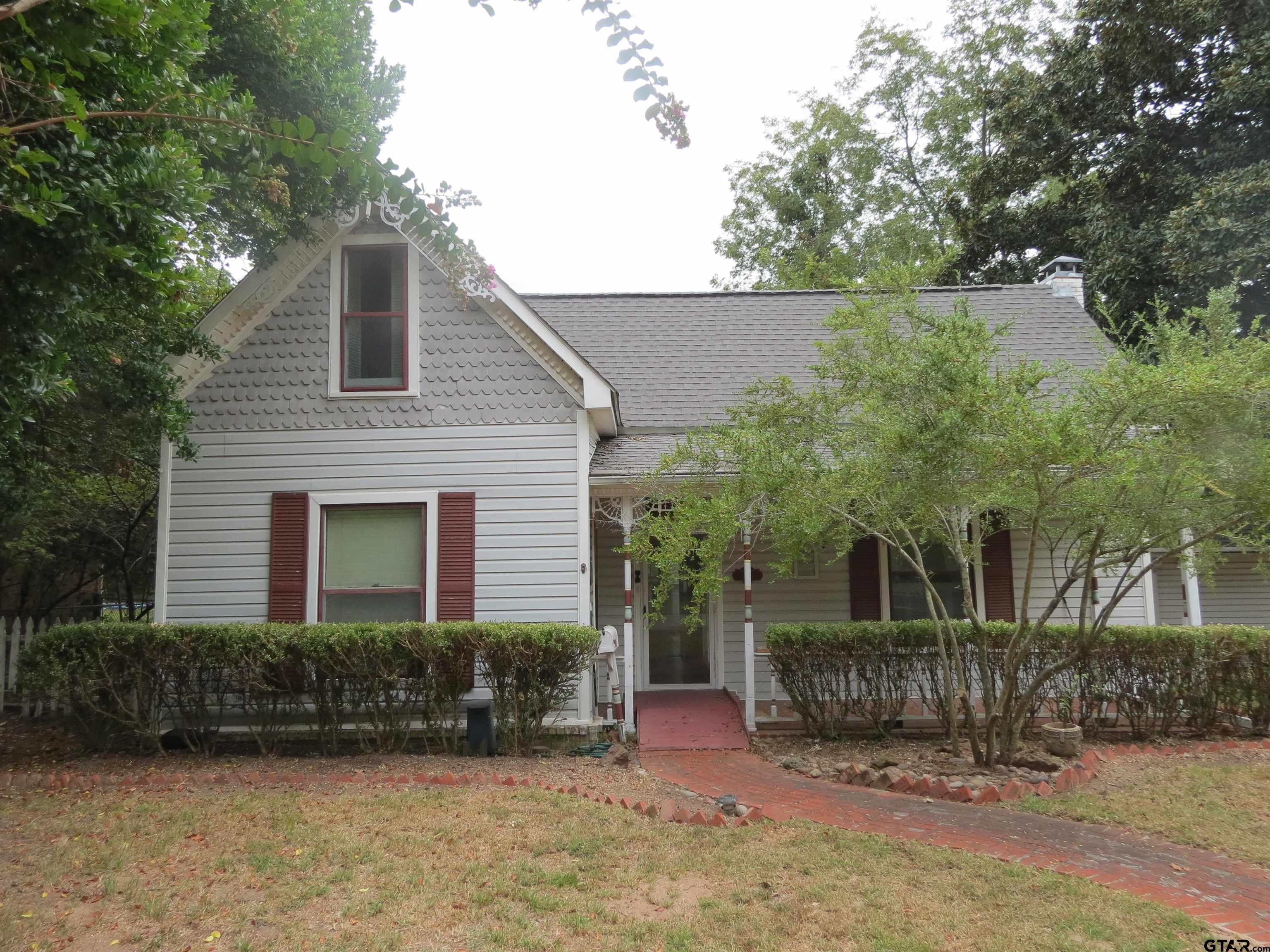 a view of a house with a yard and potted plants