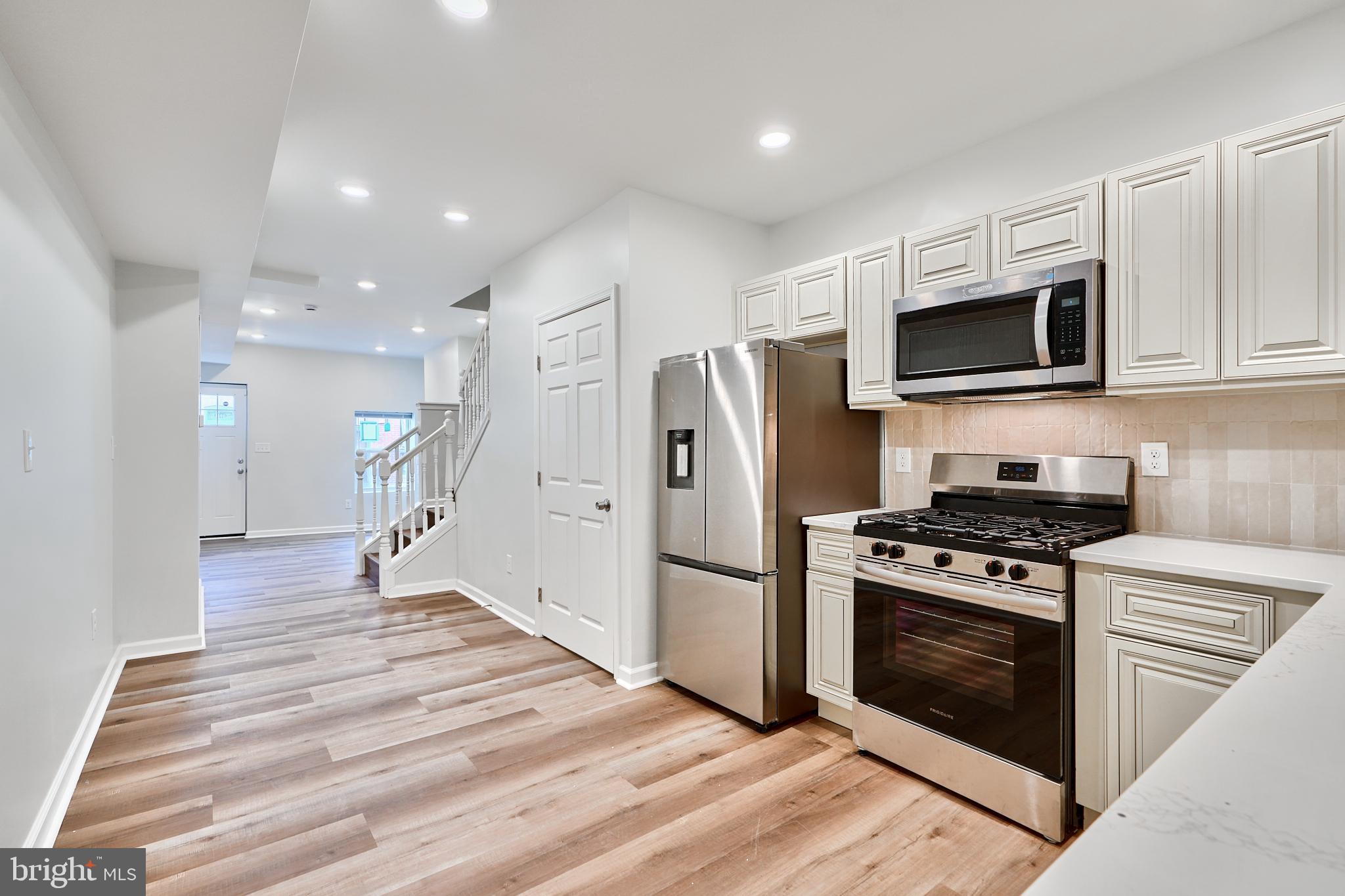 a kitchen with stainless steel appliances granite countertop a stove a refrigerator and a microwave