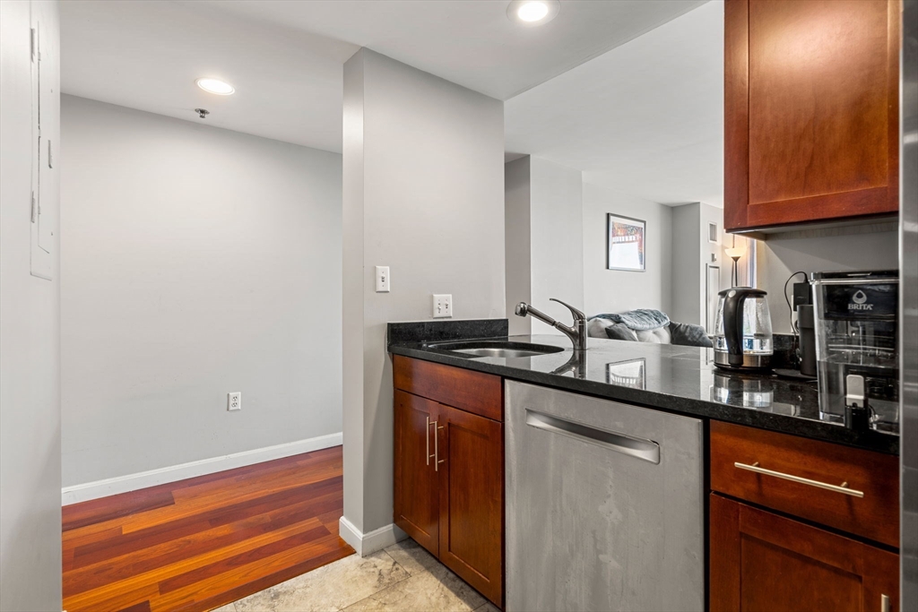 a kitchen with stainless steel appliances granite countertop a sink and dishwasher a stove with wooden floor