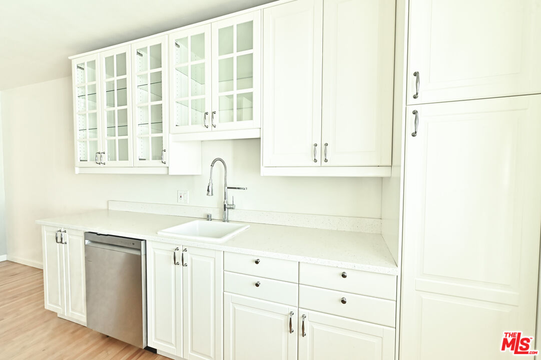 a kitchen with stainless steel appliances cabinets a large window and a sink