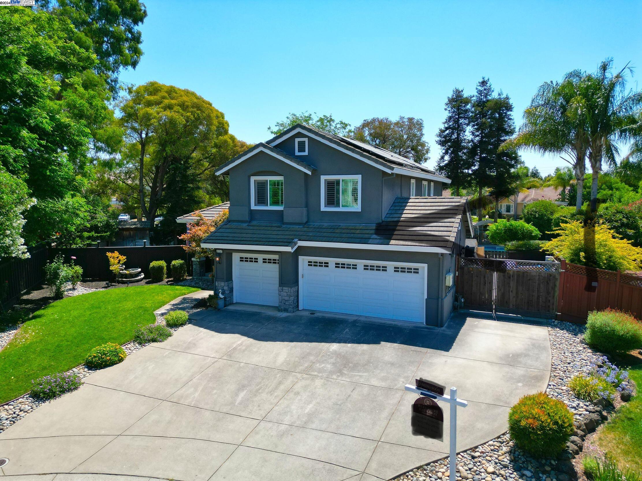 a front view of a house with a yard and potted plants