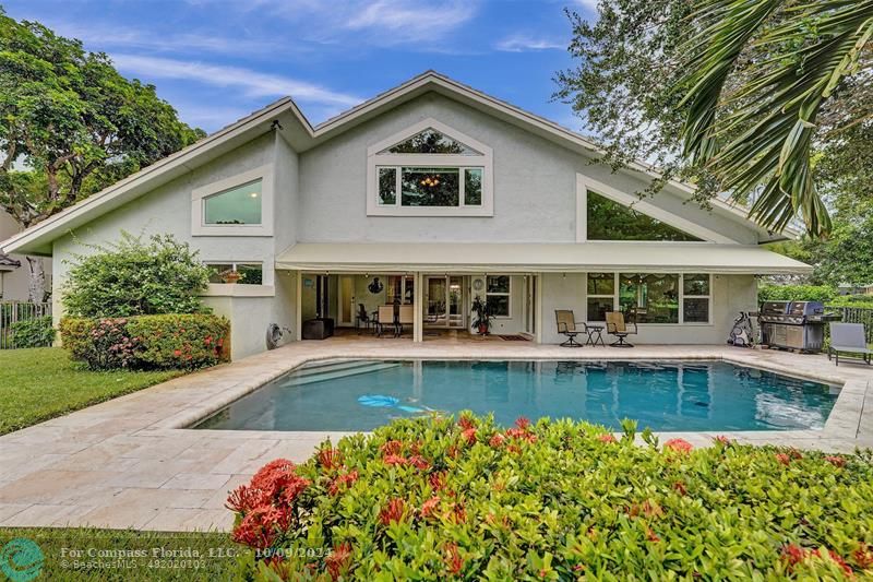 a front view of a house with swimming pool having outdoor seating