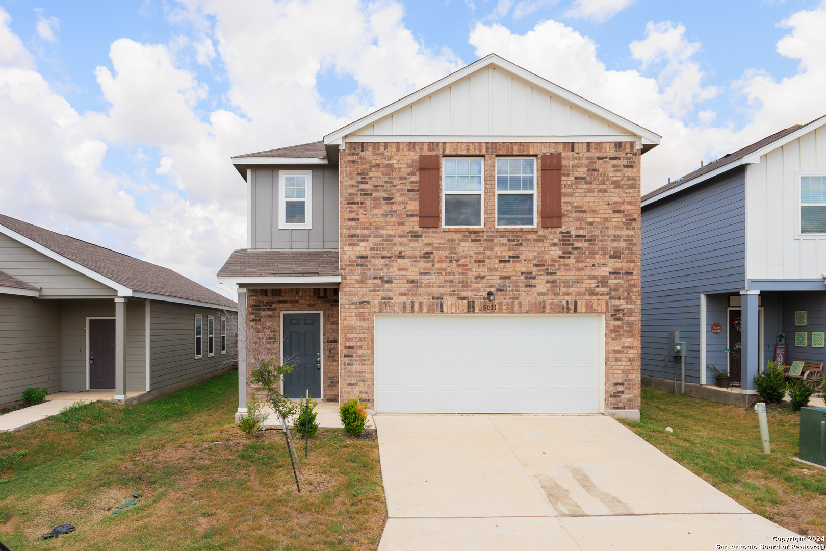 a front view of a house with a yard and garage