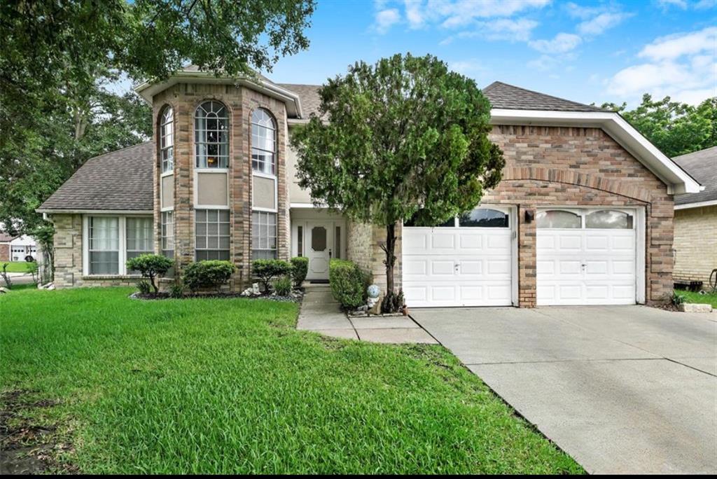 a front view of a house with a yard and garage