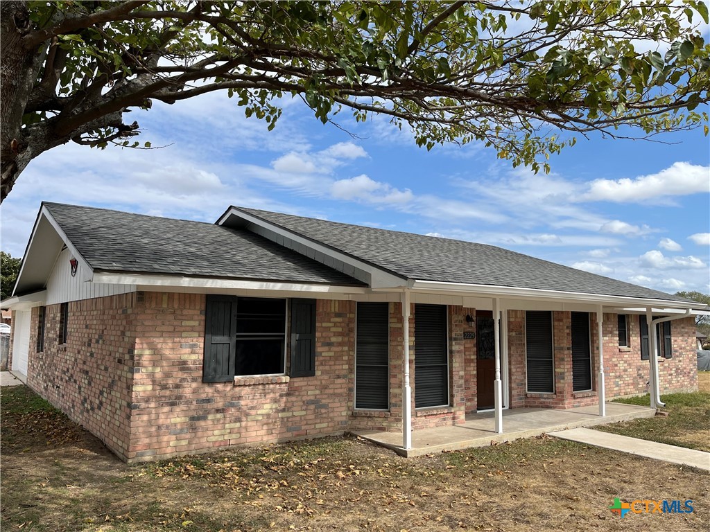 a front view of a house with a tree