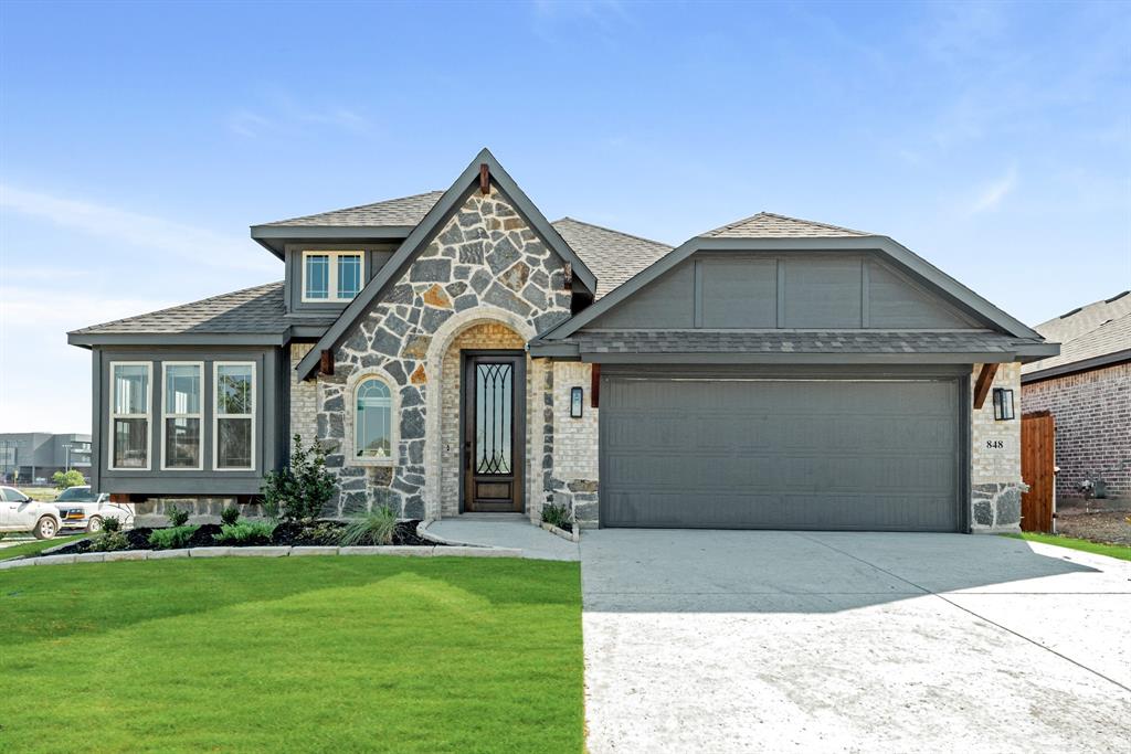 a front view of a house with a yard and garage