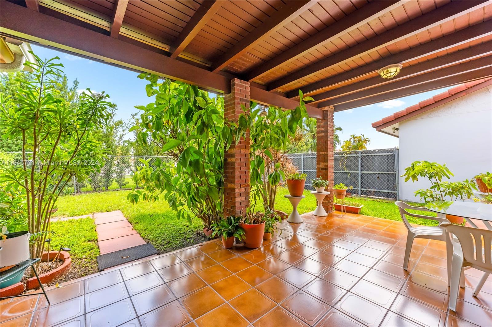 a view of a patio with table and chairs and potted plants