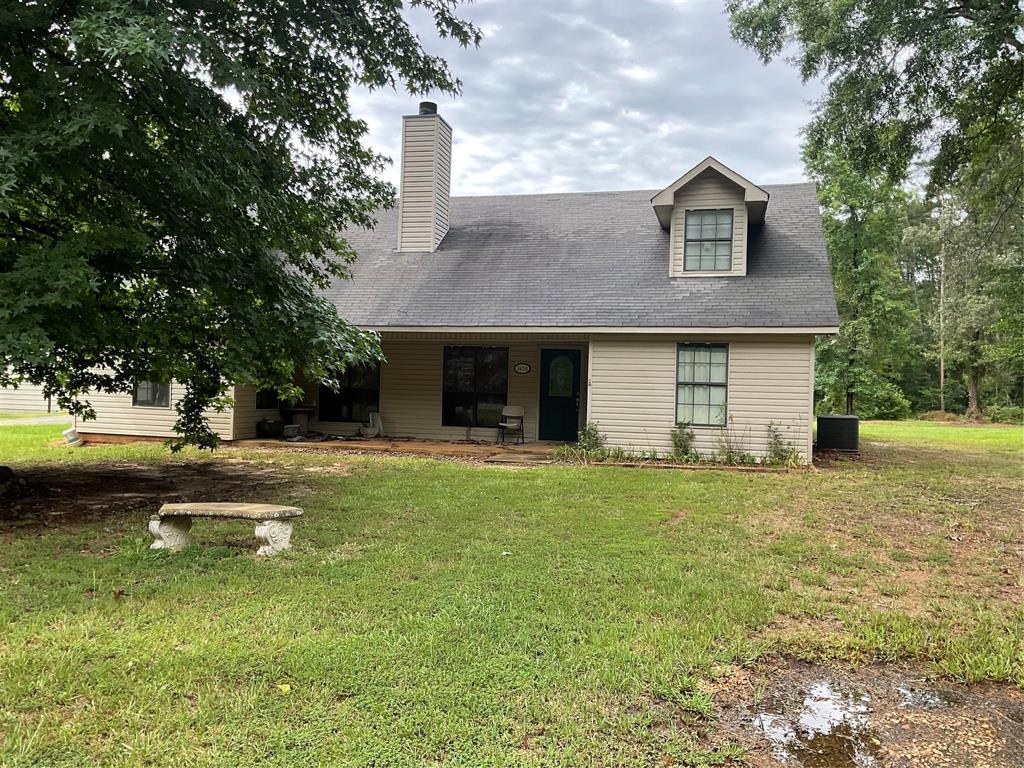 a view of a house with pool and a yard