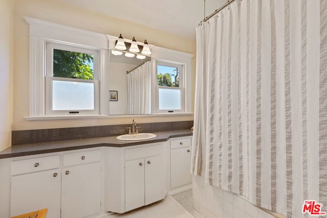 a bathroom with a granite countertop sink and a mirror