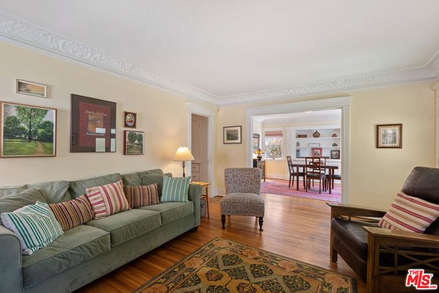 a living room with furniture a wooden floor and a lamp