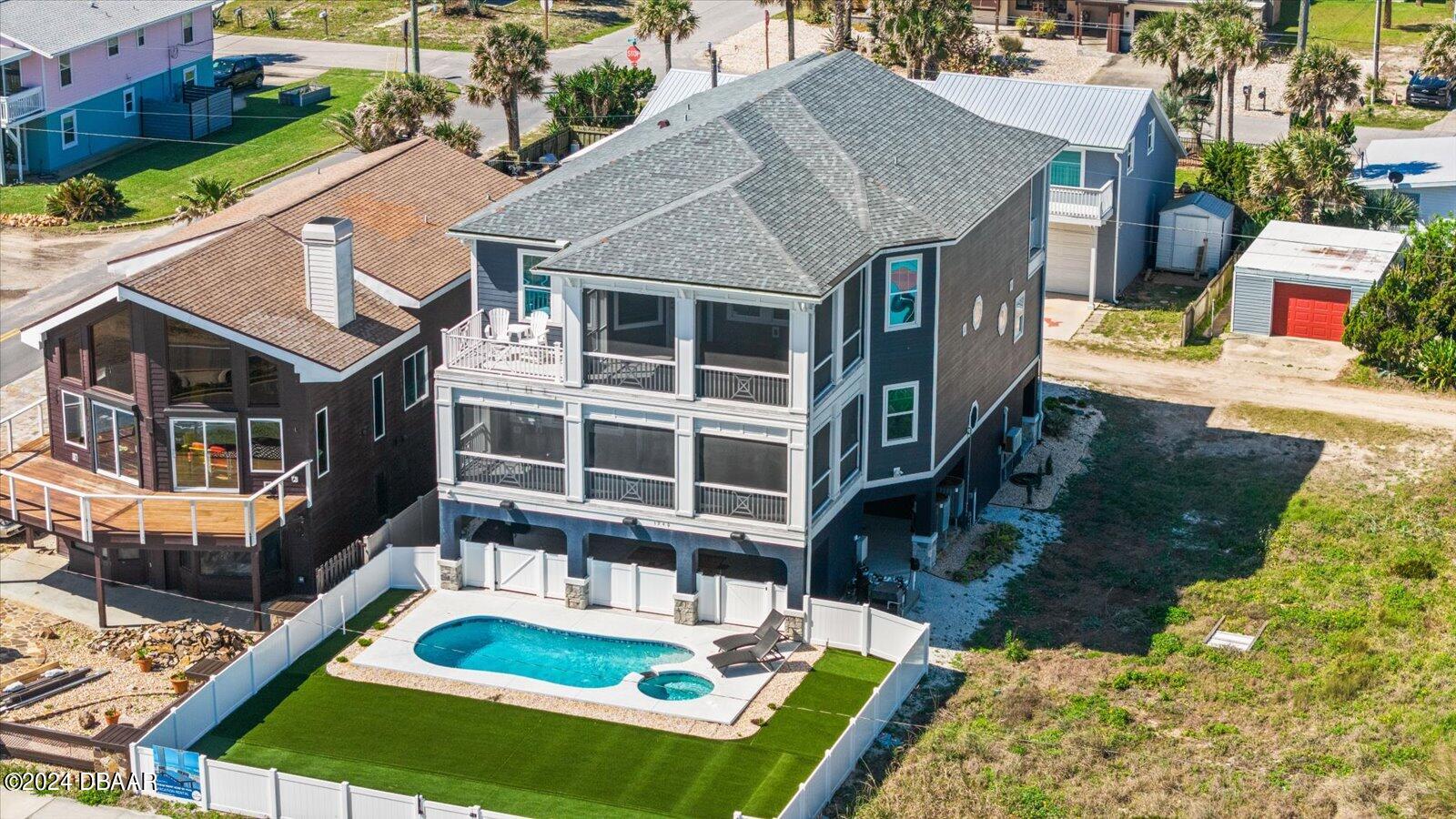 a aerial view of a house with swimming pool and a yard