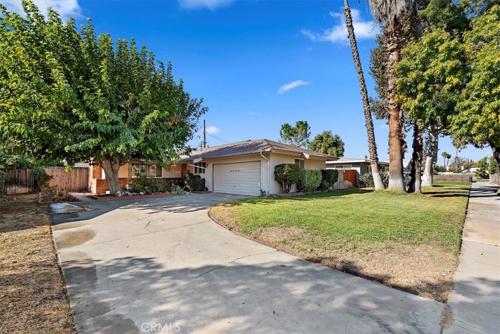 a front view of a house with a yard and trees