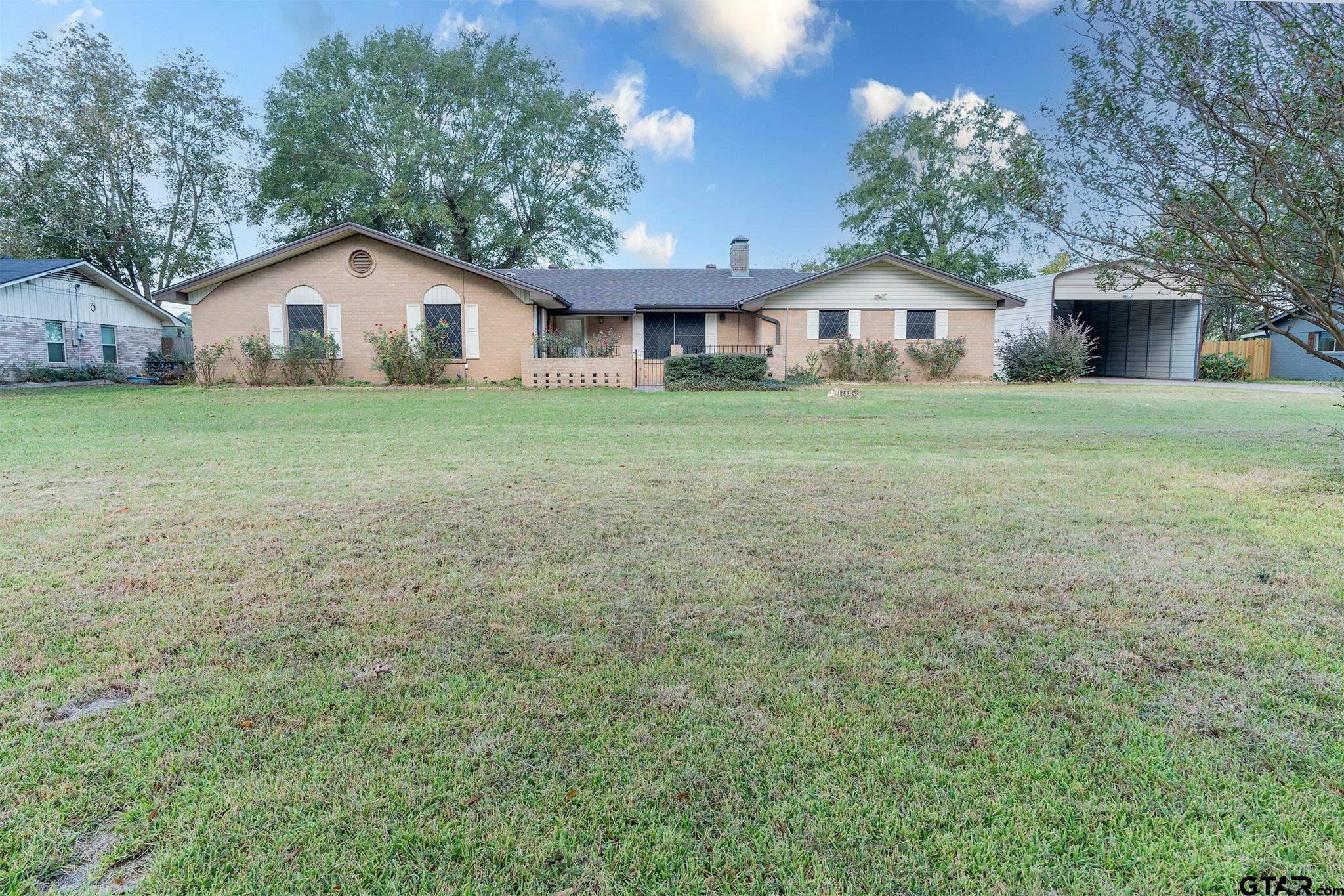 a view of house with backyard and garden