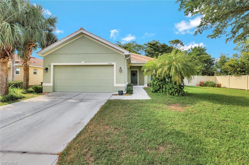 View of front of home with a garage and a front lawn