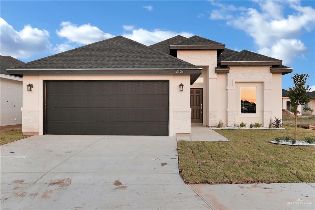 View of front of home with a front lawn and a garage