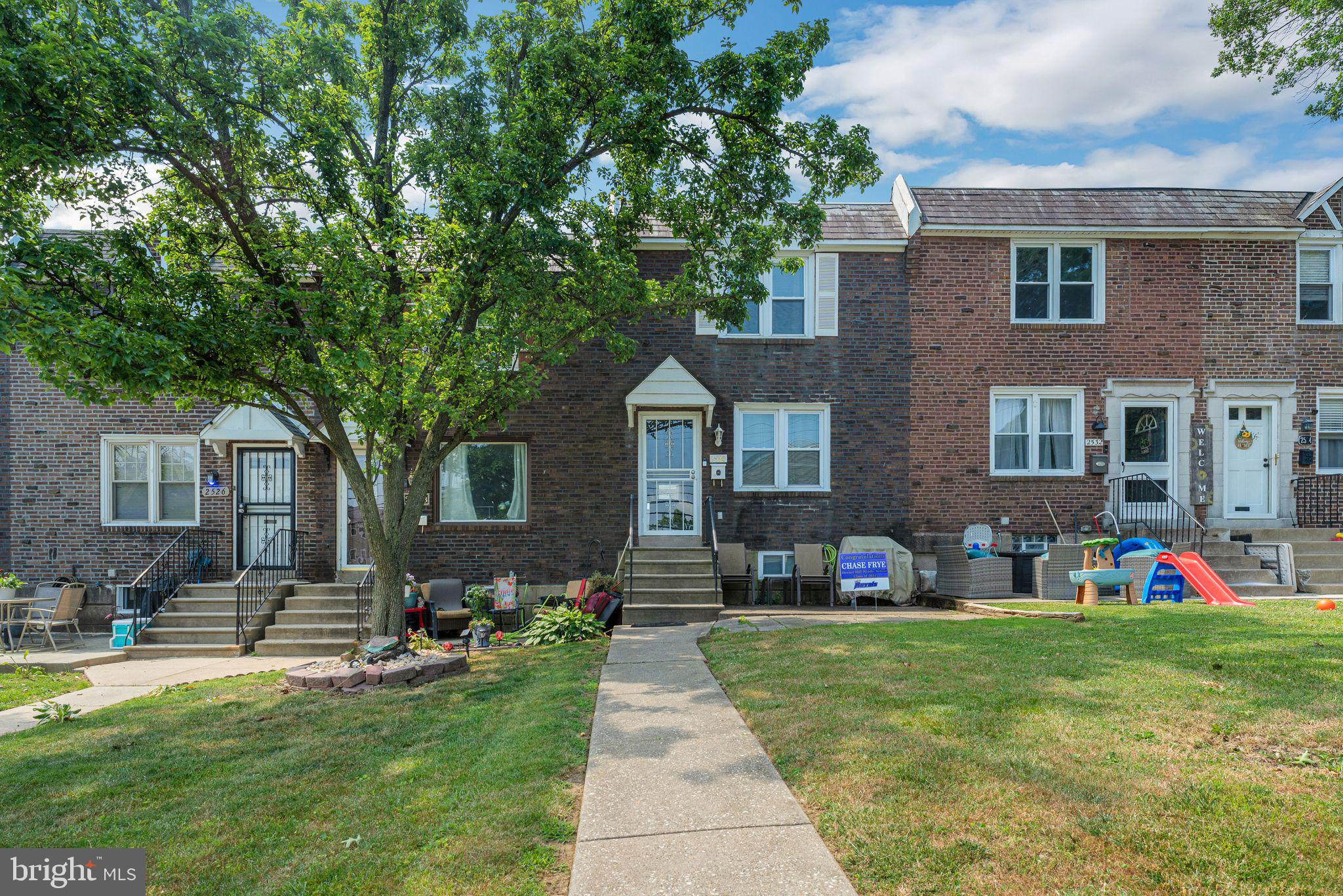 a front view of house with yard and green space