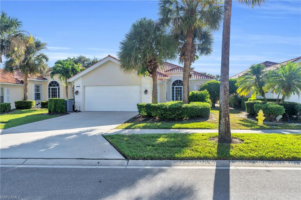 Mediterranean / spanish home with a garage, a front yard, and central air condition unit