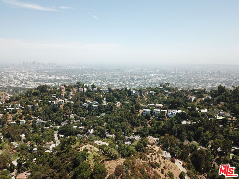 an aerial view of house with yard and mountain view in back