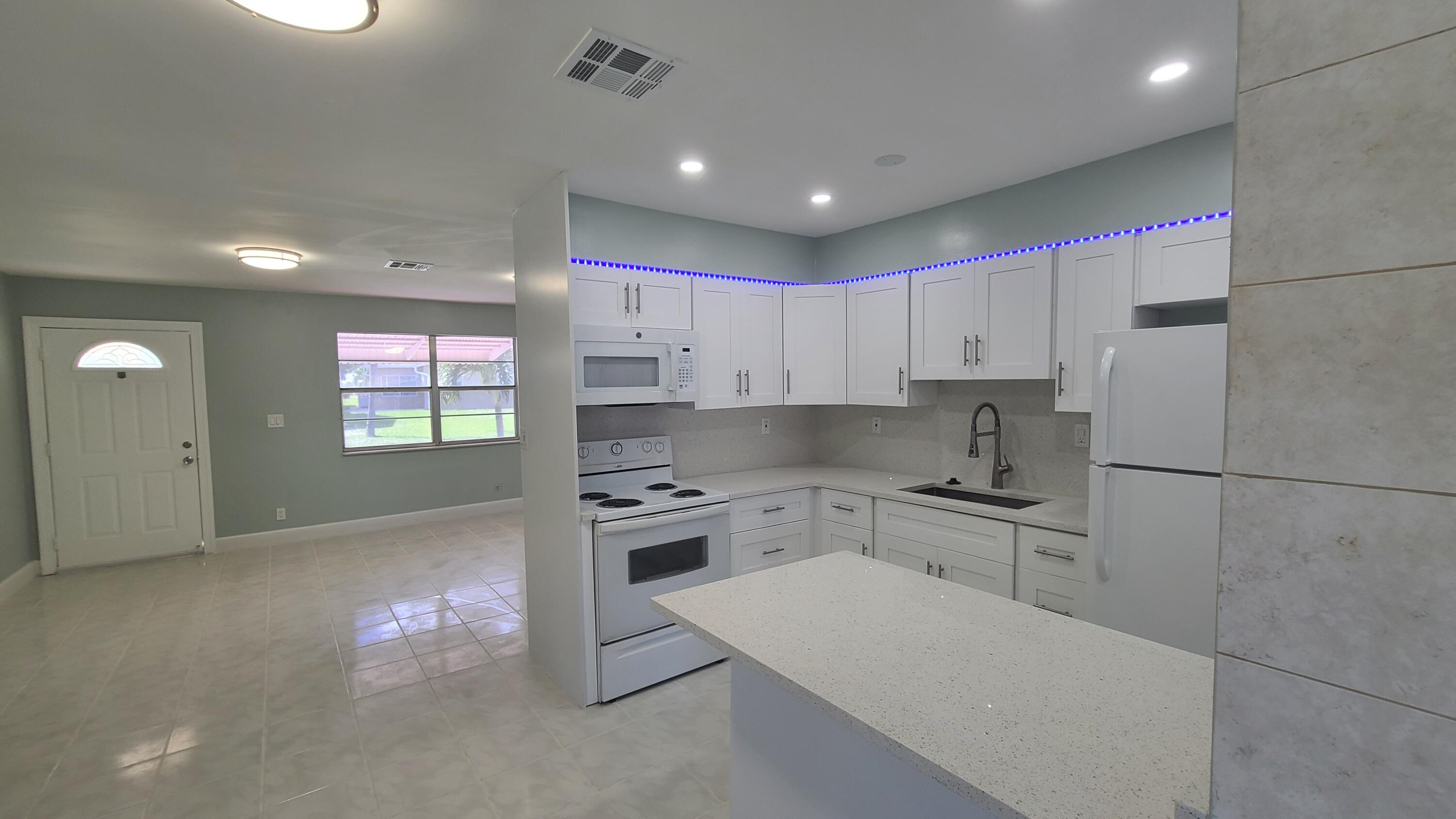 a kitchen with granite countertop a sink stove and refrigerator