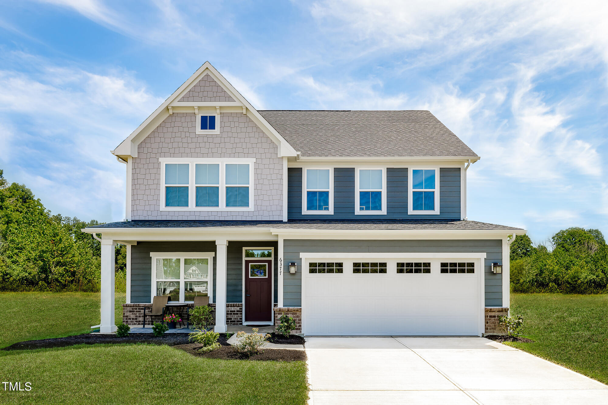 a front view of a house with a yard and outdoor seating