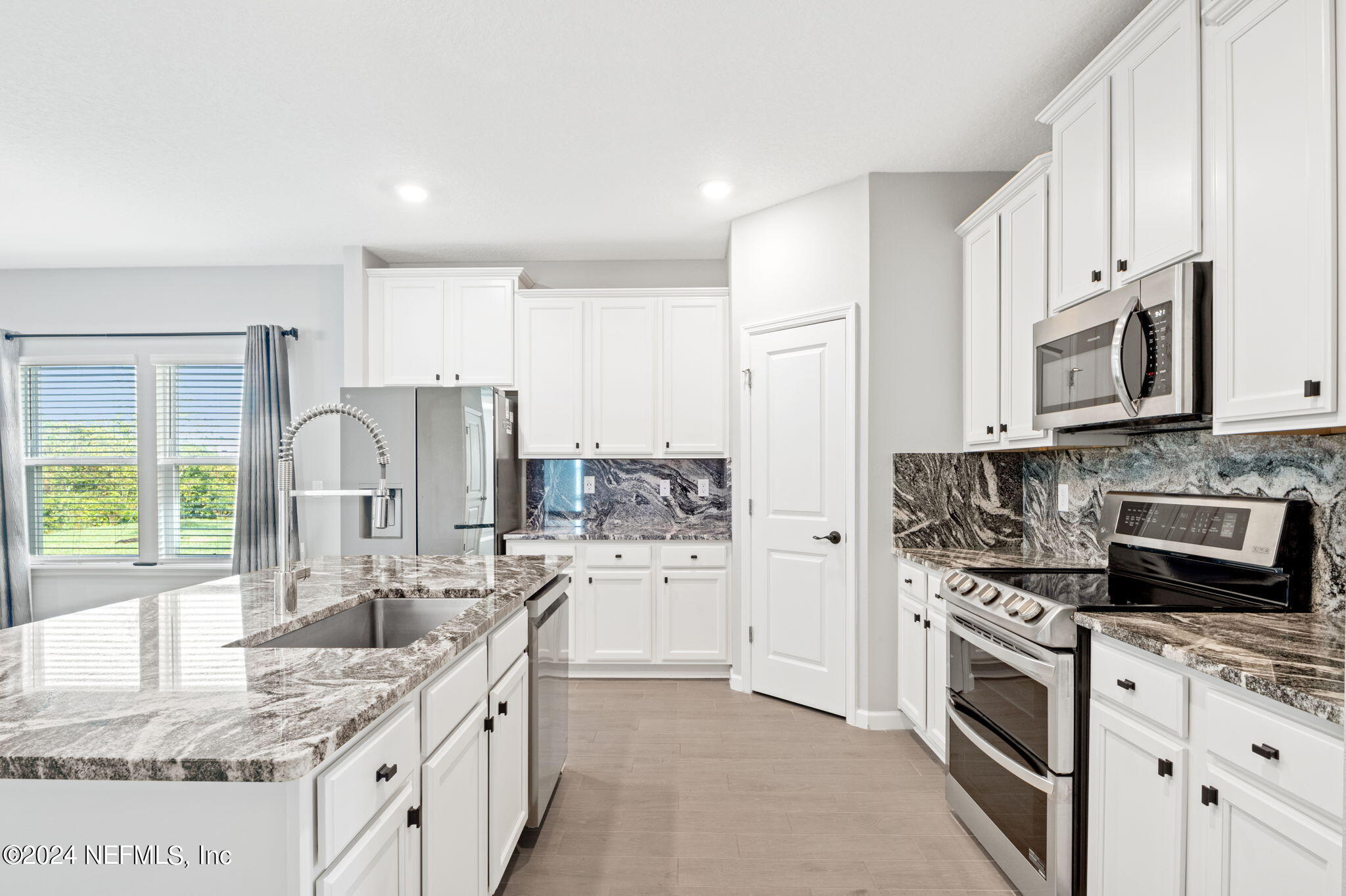 a kitchen with stainless steel appliances granite countertop a sink stove and refrigerator