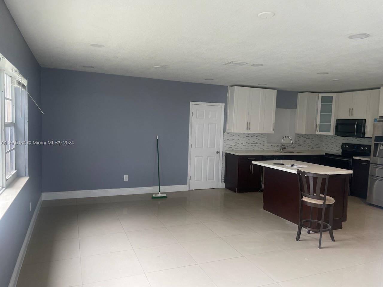 a kitchen with a refrigerator and a stove top oven