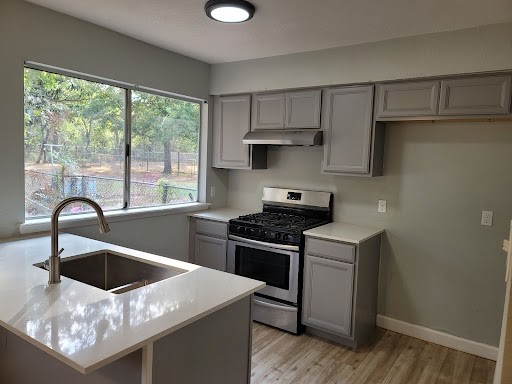 a kitchen with stainless steel appliances a sink a stove and a refrigerator