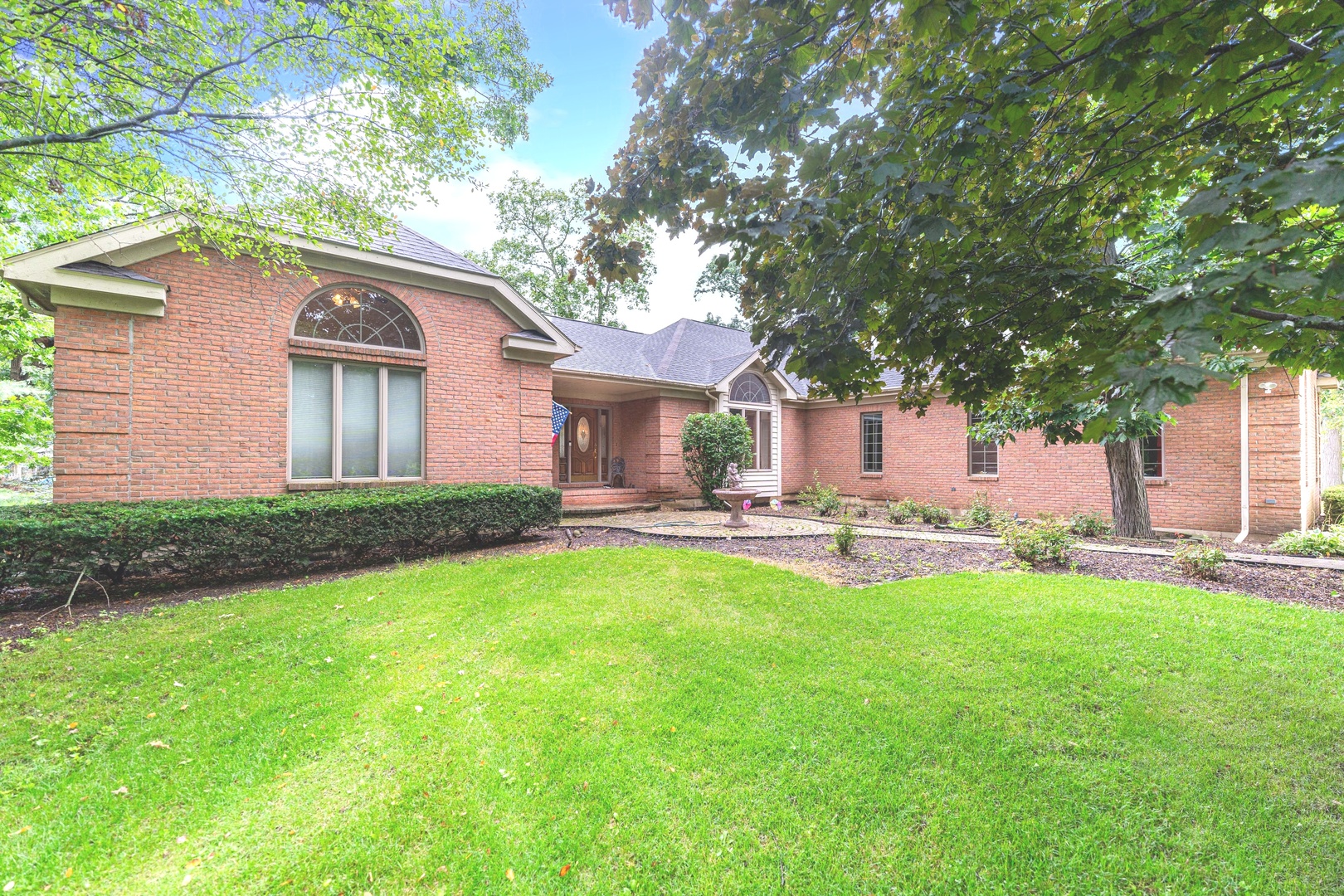 a front view of a house with yard patio and green space