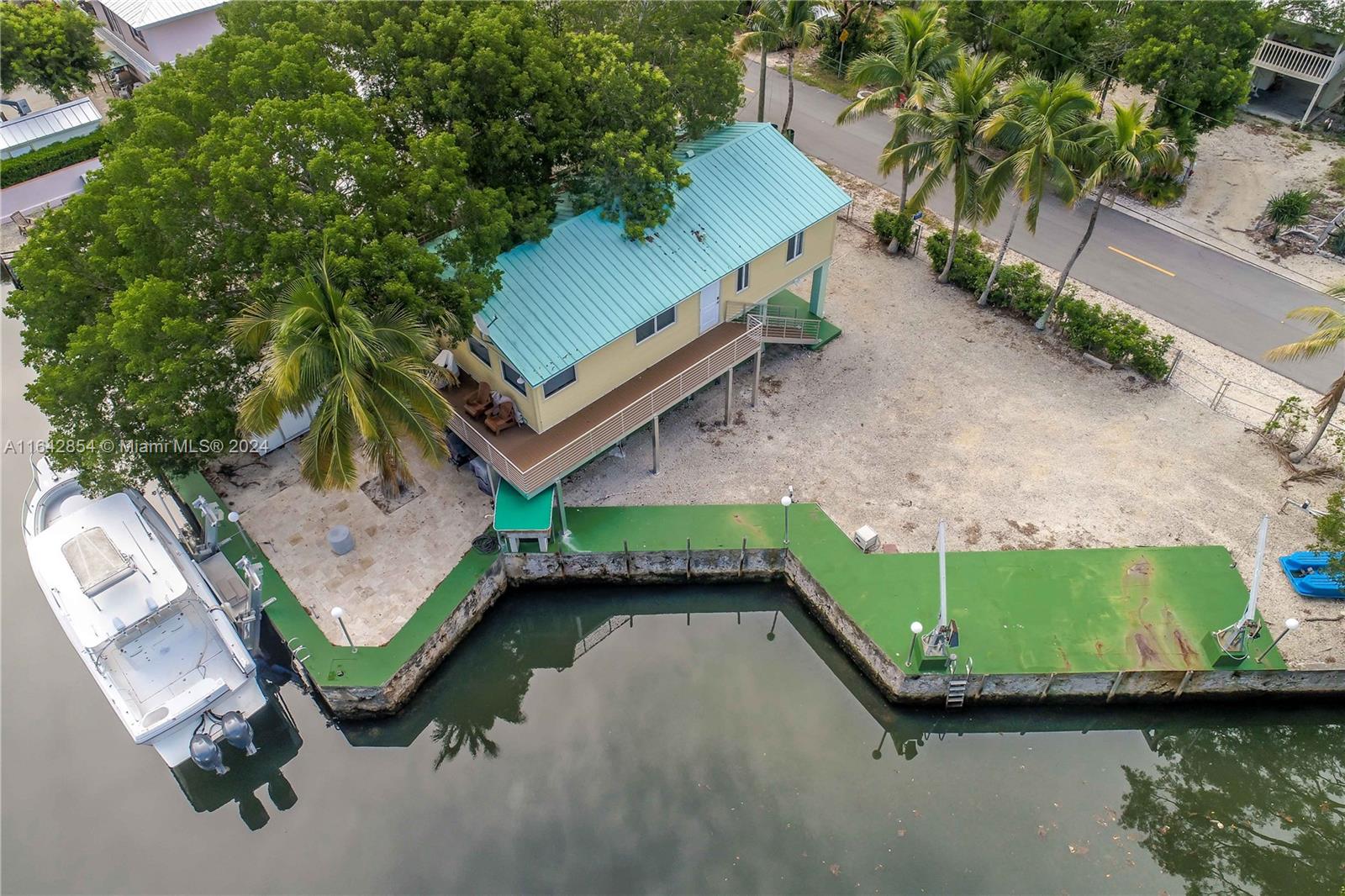 an aerial view of a house with a yard and lake view